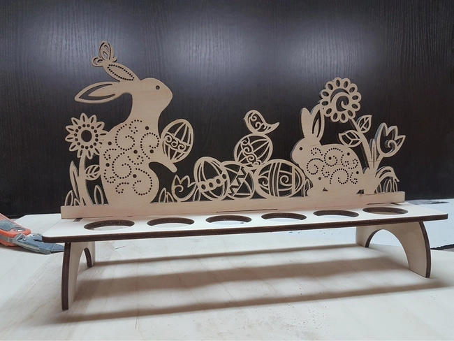 Wooden easter egg stand with flowers and rabbits